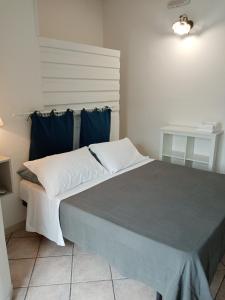 una camera da letto con un grande letto con cuscini blu di B&B Aurora's House a Castellabate