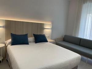 a hotel room with a white bed and white comforter at Urban Hotel in Alicante