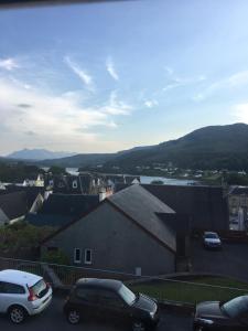 una vista de los coches estacionados en un estacionamiento en 4 York Drive, Portree , Isle Of Skye en Portree