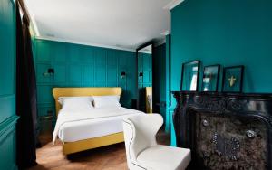 um quarto com paredes azuis e uma cama e uma cadeira em Hotel The Corner Roma em Roma