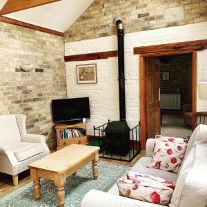 a living room with a couch and a fireplace at The Old Stable in Sleaford