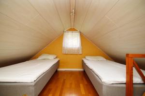 Duas camas numa tenda com uma janela em Hustugu Gård em Örsundsbro