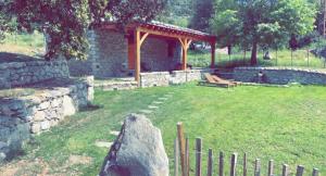 un edificio de piedra con un banco en un patio en La bergerie du Chêne en Omessa