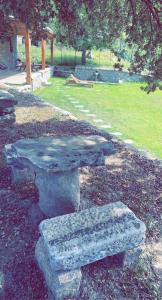 een stenen bank en een tafel in een park bij La bergerie du Chêne in Omessa