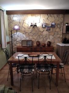 a table and chairs in a room with a stone wall at Casa Rural Lahuerta in Bronchales