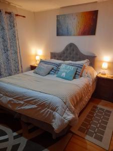 una camera da letto con un grande letto con due cuscini di Descanso Sureño Hospedaje a Valdivia