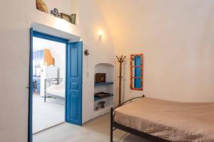 a bedroom with a bed and a blue door at Eva's Guesthouse in Éxo Goniá