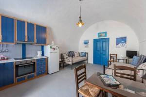 a kitchen with blue cabinets and a table and a dining room at Eva's Guesthouse in Éxo Goniá