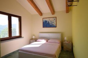 um quarto com uma cama e uma janela em Wishing Well Maratea em Maratea