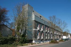 a large stone building with windows on a street at Nell-Breuning-Hotel in Herzogenrath