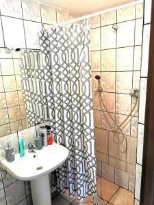 cortina de ducha en el baño con lavamanos en MARINASURF Baza Wypoczynkowa, en Przeczyce
