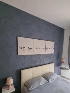 - une chambre dotée d'un lit avec 4 photos sur le mur dans l'établissement B&B L'ARANCIO, à Fossacesia