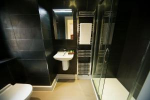 a bathroom with a sink and a shower and a toilet at East Walls Hotel in Chichester