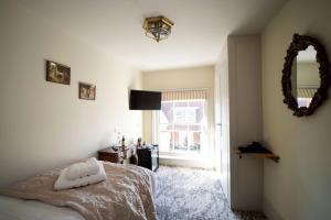 a bedroom with a bed and a mirror and a window at East Walls Hotel in Chichester