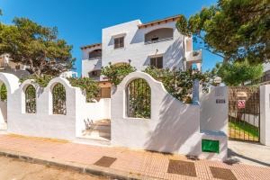 a white building with a gate in front of it at Apartamentos Karin 1ºB in Felanitx +2 photos