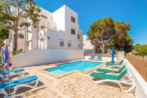 a villa with a swimming pool and lounge chairs at Apartamentos Karin 1ºB in Felanitx