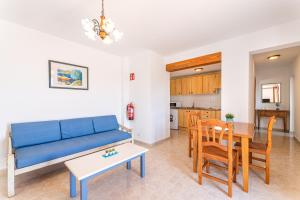 a living room with a blue couch and a table at Apartamentos Karin 1ºB in Felanitx