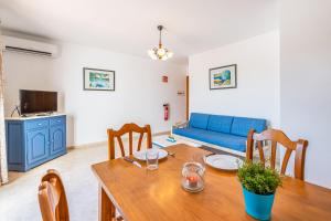 a living room with a table and a blue couch at Apartamentos Karin 1ºB in Felanitx