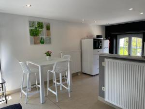 a kitchen with a table and chairs and a refrigerator at GITE D'Hotlîs in Aywaille
