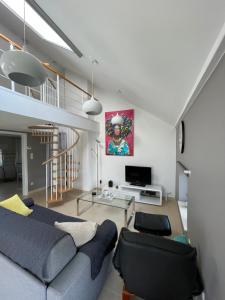 a living room with a blue couch and a tv at GITE D'Hotlîs in Aywaille