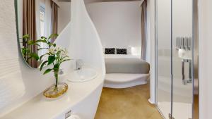 Baño blanco con aseo y lavamanos en Hotel Boutique Suite Generis, Premiado El hotel más acogedor de España, en Córdoba