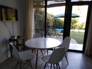 een witte tafel en stoelen in een kamer met een patio bij Mini casa in Chacras de Coria