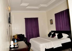 a hotel room with a bed and purple curtains at J Gibson Hotel in Lagos
