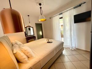 a bedroom with a white bed and a window at Hotel Acropol in Parga