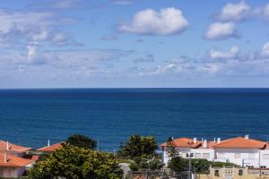 a view of the ocean with houses and buildings at Ericeira Panoramic Sea View Apartments in Ericeira