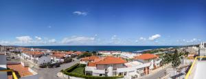 a view of a town with houses and the ocean at Ericeira Panoramic Sea View Apartments in Ericeira