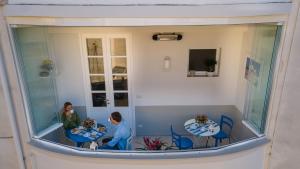 due bambini seduti ai tavoli in una stanza con finestra di Bebio Rooms a Trani