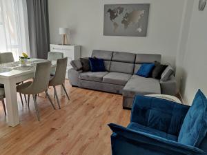 a living room with a couch and a table at Gracja Dom przy Plaży in Rogowo