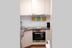 a kitchen with white cabinets and a sink at Urlaub machen wo andere arbeiten :) in Klagenfurt