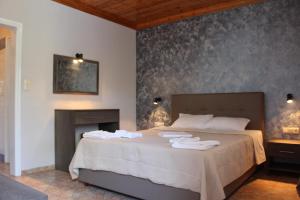 a bedroom with a bed with towels on it at VILLA IATROU in Potos