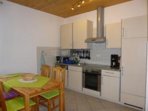 a kitchen with white cabinets and a table and chairs at Herrenhaus Poppelvitz in Maltzien +19 photos