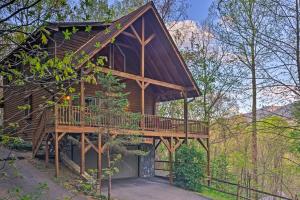 a tree house with a deck in the woods at Spacious Maggie Valley Cabin with Hot Tub and MTN View in Maggie Valley