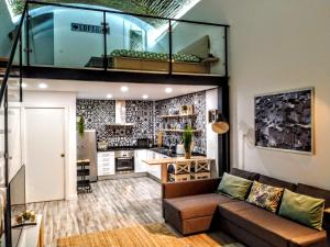 a living room with a couch and a kitchen at Loft Porte Sud in Olhão