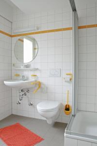 een badkamer met een toilet, een wastafel en een douche bij Nell-Breuning-Hotel in Herzogenrath