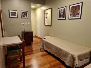 1 dormitorio con cama, mesa y escritorio en (109)Flat Poeta Drummond Jardins (Apt Particular), en São Paulo