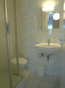 a bathroom with a sink and a toilet and a mirror at GastHaus Hotel Bremen in Bremen