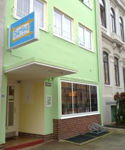 a green building with a sign on the side of it at GastHaus Hotel Bremen in Bremen