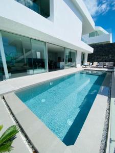 una piscina davanti a una casa di Luxury Villa - new building with panoramic sea view ad Adeje
