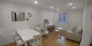 biały salon ze stołem i krzesłami w obiekcie Cómodo apartamento en zona antigua dos w mieście Pontevedra