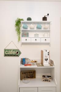 a white shelf with dishes and a sewing machine on it at Vento del sud in Modica