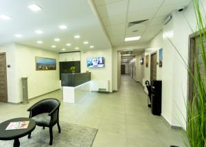 a hospital hallway with a chair and a table at Downtown Suites Yerevan in Yerevan