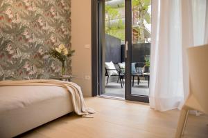 sypialnia z łóżkiem i przesuwnymi szklanymi drzwiami w obiekcie RICCIONE SUITE DESIGN w mieście Riccione