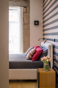uma cama num quarto com uma janela e uma mesa em Kbirr Charming House em Nápoles