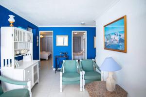 een woonkamer met blauwe muren en blauwe stoelen bij Casa do Cais in Calheta