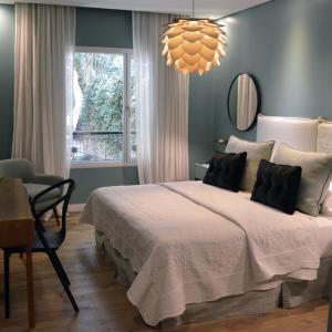 Un dormitorio con una cama grande y una lámpara de araña. en Villa Isidro Hotel Boutique & Spa en San Isidro