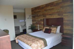 a bedroom with a large bed with a wooden headboard at Wheel Inn Motel in Assiniboia
